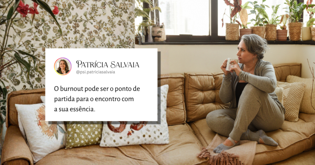 Mulher sentada confortavelmente, segurando uma xícara de chá quente enquanto observa a vista pela janela. Sua expressão é de serenidade e reflexão, simbolizando a pausa necessária e o processo de cura do burnout através da terapia junguiana online.